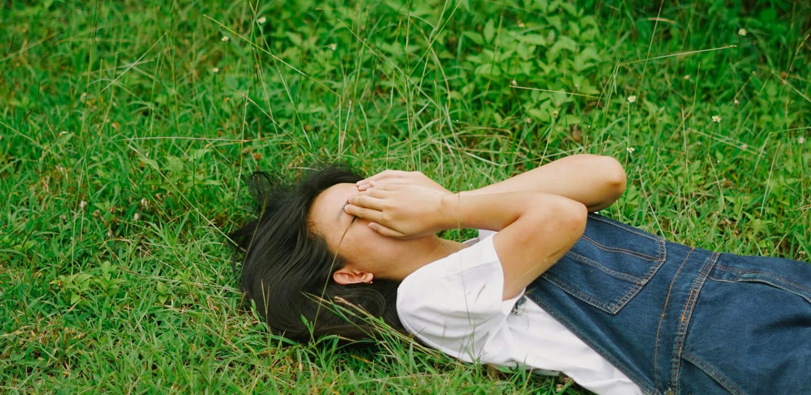 Préménopause à 40 ans : symptômes, causes et solutions naturelles Femme fatiguée dans l'herbe
