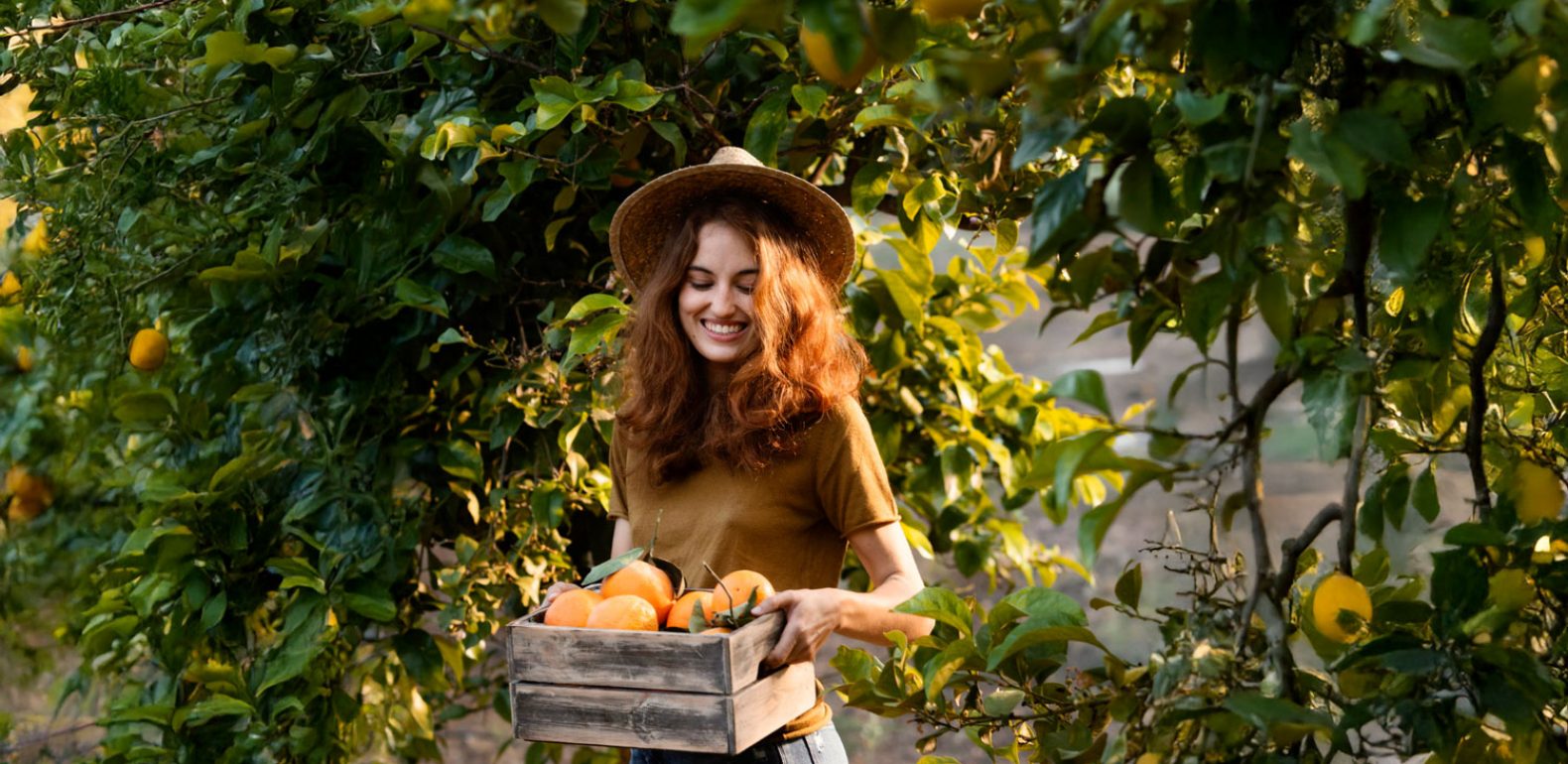 Le plein d’aliments pour booster votre énergie rapidement Femme qui porte une cagette d'oranges