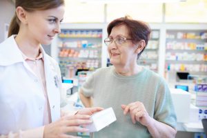 Pharmacienne conseillant une dame âgée