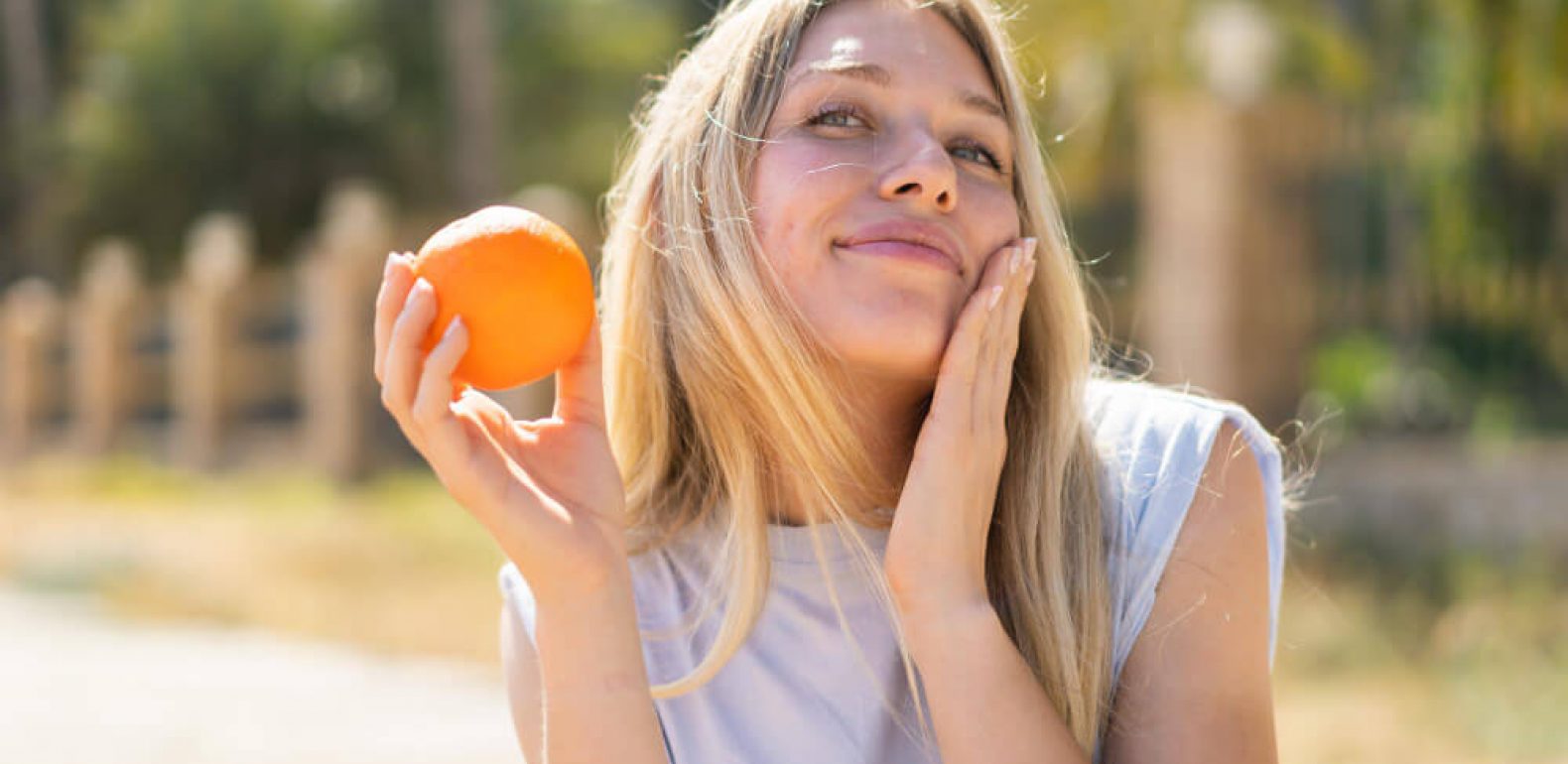 Femme avec une orange au soleil