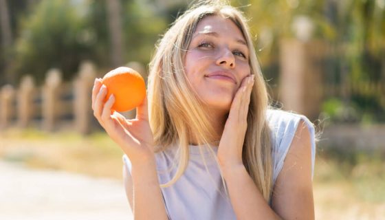 Femme avec une orange au soleil