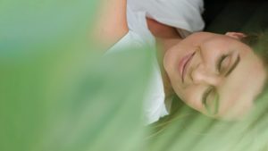 Femme souriante avec plante en premier plan