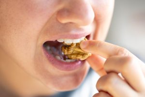 Femme qui mange une noix
