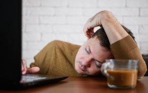 Homme fatiguée et allongé sur le bureau devant son ordinateur