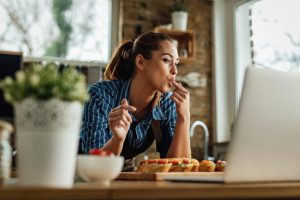 Femme qui mange devant son ordinateur
